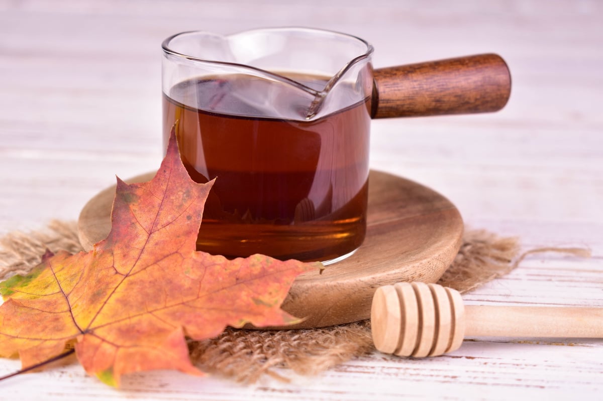Placeholder product photo — maple syrup in a glass container with maple leaves, ready for the seller's own image